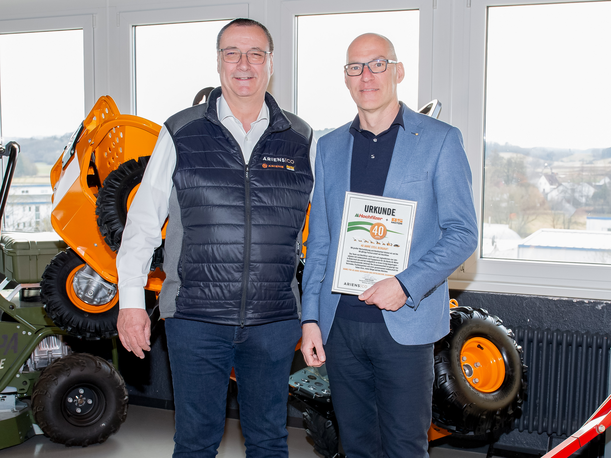 Jochen Schneider, Executive Vice President AriensCo EMEAA übergibt Geschäftsführer der Hochfilzer GmbH & Co KG Ronald Hrnecek die Urkunde für 40 Jahre Partnerschaft.