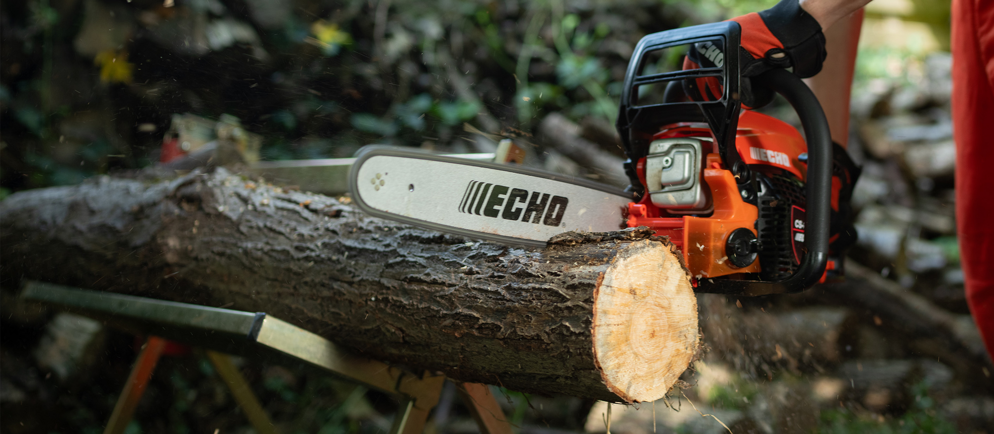 Das leichte Einstiegsmodell ECHO CS-3410 Kettensäge beim Sägen von Holz auf einem Sägebock
